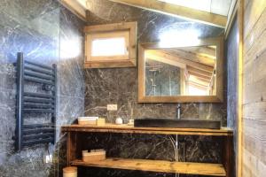 La salle de bains est pourvue d'un lavabo et d'un miroir. dans l'établissement Chalet vue Mont Blanc avec jacuzzi extérieur, à Combloux