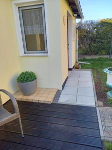 une terrasse couverte d'une maison avec une chaise et une fenêtre dans l'établissement Ferienwohnung Kransevitz, à Kransevitz