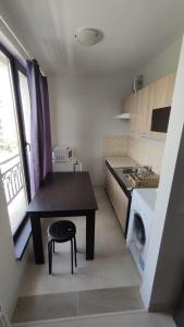 a small kitchen with a table and a washing machine at U-DACHA 45 in Sunny Beach