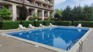 a large swimming pool with chairs and a building at U-DACHA 45 in Sunny Beach