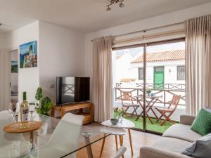 a living room with a glass table and white chairs at BLUE WATERS Apartment with heated pool in Costa Del Silencio