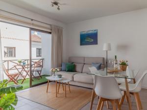 a living room with a couch and a table at BLUE WATERS Apartment with heated pool in Costa Del Silencio