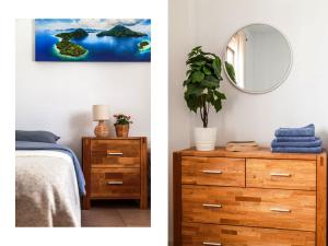 a bedroom with a bed and a dresser with a mirror at BLUE WATERS Apartment with heated pool in Costa Del Silencio +38 photos