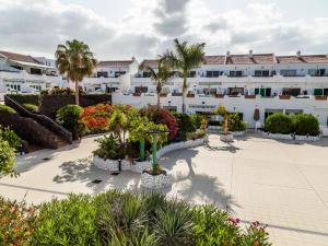 a courtyard of a hotel with palm trees and plants at BLUE WATERS Apartment with heated pool in Costa Del Silencio