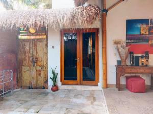 an entrance to a house with two wooden doors at Happiness Villa 1BR+Private Pool @Seminyak in Seminyak