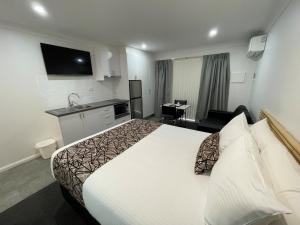 um quarto de hotel com uma cama grande e uma cozinha em Zig Zag Motel & Apartments em Lithgow