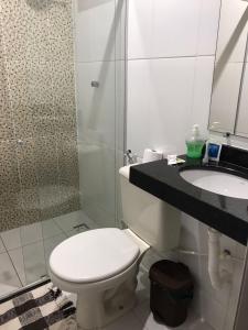 a bathroom with a toilet and a sink and a shower at Pousada Nativo's in Nova Almeida