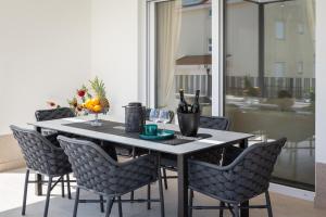a dining room table with chairs and a table with wine glasses at A&D Deluxe apartments Dani with swimming pool in Promajna
