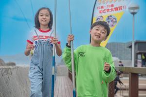 zwei kleine Kinder, die nebeneinander stehen und Schirme halten in der Unterkunft Awakan in Sumoto