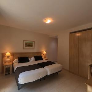 a large bedroom with two beds and two lamps at Hotel Cubil in Pas de la Casa