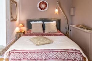 a bedroom with a large bed with white sheets and pillows at La Bastide du Mûrier in Cotignac