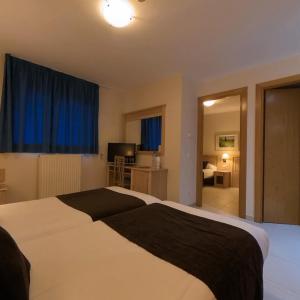 a bedroom with a large bed with blue curtains at Hotel Cubil in Pas de la Casa