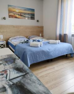 1 dormitorio con 2 camas y sábanas azules en Apartamenty u Rybaka, en Jastarnia