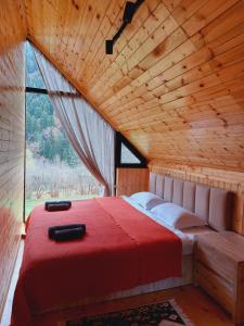 Cama en habitación de madera con ventana grande en Iano, en Oni