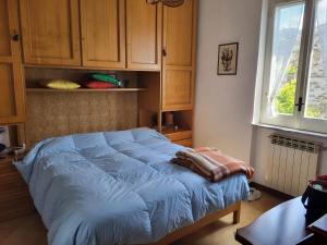 a bed in a bedroom with wooden cabinets and a window at Casa Del Fico in Montecorice