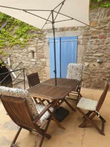 une table en bois avec deux chaises et un parasol dans l'établissement Lou-Pelou, à Gravières