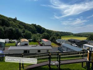 a view of a town with a fence and houses at Kates Home Lagganhouse Woodland Way 19 in Ballantrae