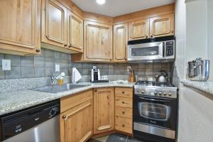 a kitchen with wooden cabinets and a sink and a stove at Adventure Hub-Ski Resorts, Backcountry & Park City 3011 villa in Midway
