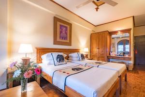 una camera da letto con due letti e un tavolo di Hotel Casamara a Kandy