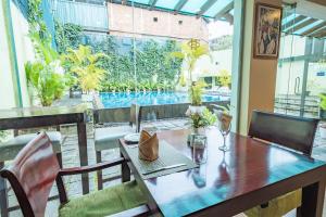 a dining table and chairs with a view of a pool at Hotel Casamara in Kandy