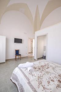 - une chambre blanche avec un lit et une télévision dans l'établissement Villa Pamela, à Barbarano