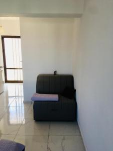a black couch sitting in the corner of a room at Studios Litsa in Pefkari