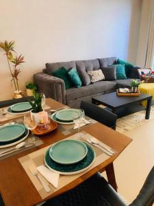 a living room with a table with green plates on it at Beach Dream - a luxury 1 bedroom apartment with direct beach access in Ras al Khaimah