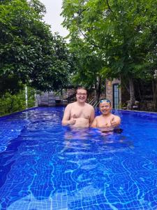 dos hombres están sentados en una piscina en Tianmen Mout Tian's Resort, en Zhangjiajie