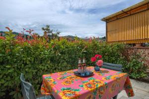 a table with a colorful table cloth and flowers on it at The house in red: per un soggiorno pieno di vitalità:mare,sole,passeggiate in Imperia