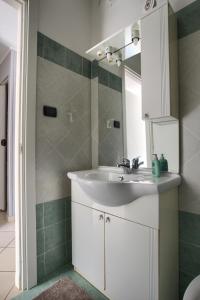 a bathroom with a white sink and a mirror at The house in red: per un soggiorno pieno di vitalità:mare,sole,passeggiate in Imperia