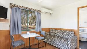 a living room with a couch and a table at Apex RiverBeach Holiday Park in Mildura