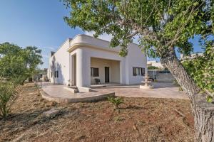 une maison blanche avec un arbre au premier plan dans l'établissement Villa Pamela, à Barbarano