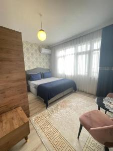 Smf Suites 2+1 5 Luxery Flat Good Location في إسطنبول: غرفة نوم بسرير وملاءات زرقاء ونافذة