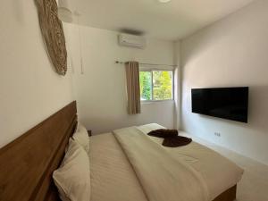 1 dormitorio con 1 cama y TV de pantalla plana en New Private Pool Villa, en Baan Tai
