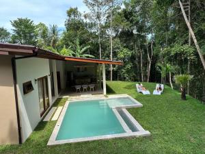 a swimming pool in a yard next to a house at New Private Pool Villa in Ban Tai