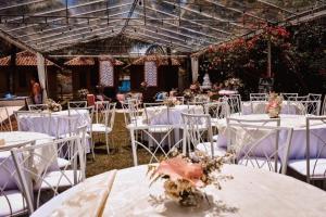 a group of tables with white chairs and flowers at Pousada Nativo's in Nova Almeida +111 photos
