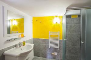 uma casa de banho com um lavatório e um chuveiro em B&B Perla del Sud em Collepasso