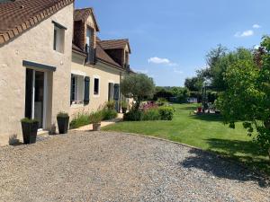 a driveway leading to a house with a yard at Agréable chambres d’hôte in Parence