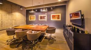 a conference room with a wooden table and chairs at CozySuites l 2BR Loft, Monument Circle, Indy in Indianapolis