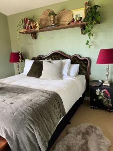 a bedroom with a large bed with white sheets and pillows at Fridas Accommodation in Raglan