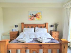 a bedroom with a large wooden bed with two towels at Spacious Home in West Moonah, Hobart in Moonah