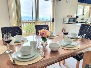 a dining room table with plates and glasses of wine at Spacious Home in West Moonah, Hobart in Moonah
