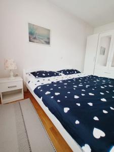 - une chambre avec un lit et une couette bleue et blanche dans l'établissement Mia, à Tomislavgrad