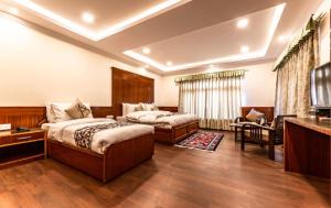 ein Hotelzimmer mit 2 Betten und einem TV in der Unterkunft Hotel Alpine Ladakh in Leh