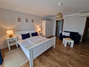 een slaapkamer met een groot bed en een bank bij Guesthouse Barica in Crikvenica