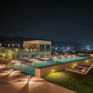 a large swimming pool at night with lights at Marriott Executive Apartments Navi Mumbai in Navi Mumbai