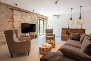 een woonkamer met een bank en stoelen en een tv bij Villa Vittorina - New Rental in Svetvinčenat