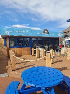 a blue picnic table on a deck in front of a building at The Powers in Rhyl