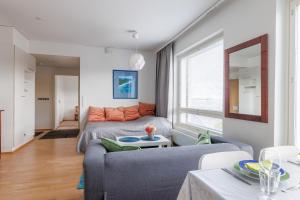 un soggiorno con divano e letto di Close to center and Näsijärvi Lake - free parking, AC, and two double beds a Tampere