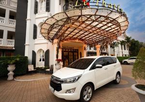 a white car parked in front of a building at Le Thatluang D'oR Boutique Hotel in Vientiane